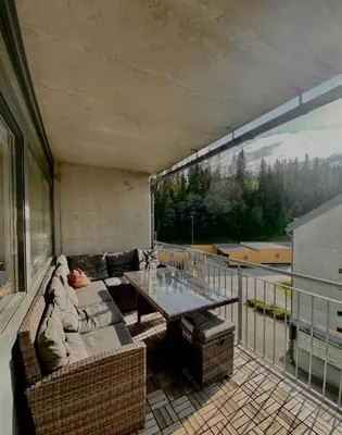 a living room with a couch and a table on a balcony at Lægdgrinda 11 in Trondheim