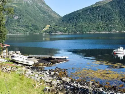 two boats are docked at a dock on a lake at 7 person holiday home in VÅGLAND in Vågland
