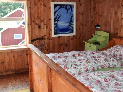 a bedroom with a bed in a wooden room at 7 person holiday home in VÅGLAND in Vågland