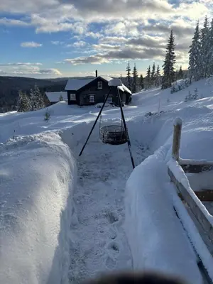 a yard covered in snow with a house in the background at Ny moderne hytte i Aust-Torpa in Aust-Torpa