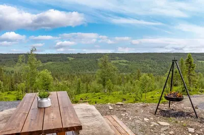 a picnic table with a view of a forest at Ny moderne hytte i Aust-Torpa in Aust-Torpa