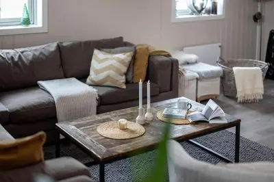 a living room with a couch and a table with books at Skoglund privat Villa in Trysil