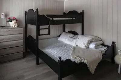 a bedroom with a black bunk bed with white pillows at Skoglund privat Villa in Trysil