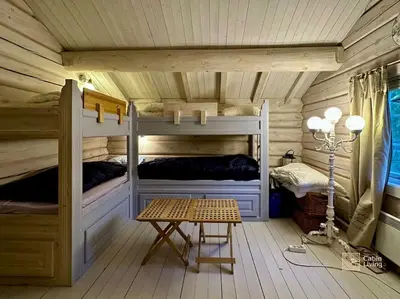 a room with two bunk beds and a table at Log cabin in Hafjell with ski in ski out, sauna and view in Hafjell