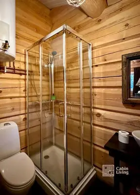 a bathroom with a toilet and a glass shower at Log cabin in Hafjell with ski in ski out, sauna and view in Hafjell