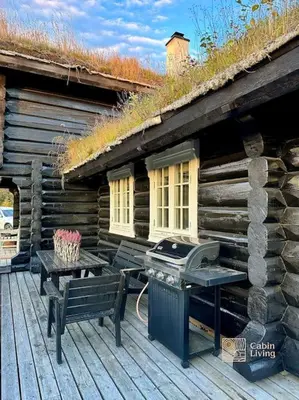 a wooden cabin with a grill and a bench on a deck at Log cabin in Hafjell with ski in ski out, sauna and view in Hafjell