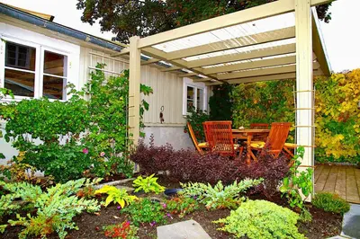 a patio with a table and chairs under a pergola at Villa Paradiso, Cathedral View & Parking in Trondheim