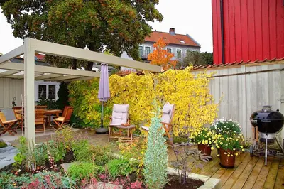 a patio with an umbrella and chairs and a fence at Villa Paradiso, Cathedral View & Parking in Trondheim