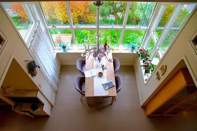 a dining room with a table and chairs and a large window at Villa Paradiso, Cathedral View & Parking in Trondheim