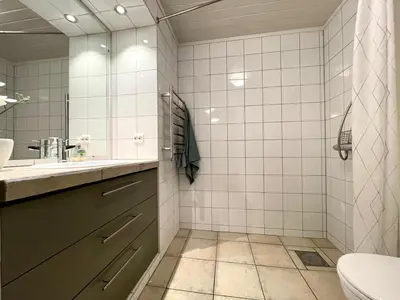 a bathroom with a sink and a toilet and a mirror at Villa Paradiso, Cathedral View & Parking in Trondheim