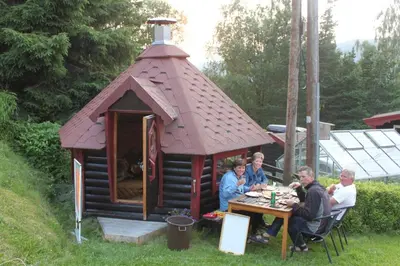 a group of people sitting at a table in a dog house at Kvila Hytteutleie in Garmo