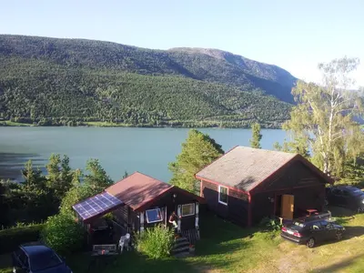 a small cabin with a view of a lake at Kvila Hytteutleie in Garmo