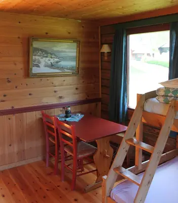 a dining room with a table and chairs in a cabin at Kvila Hytteutleie in Garmo