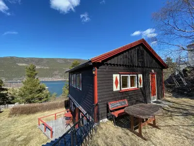 a small house with a picnic table in front of it at Kvila Hytteutleie in Garmo