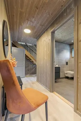 a bathroom with a wooden ceiling and a chair at Moderne hytte på Fjellsætra med Jacuzzi in Sykkylven