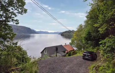 a house on the side of a body of water at 3 Bedroom Stunning Home In Omastrand in Sanddal