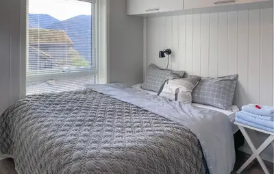 a bedroom with a large bed with a window at 3 Bedroom Awesome Home In Nordfjordeid in Nordfjordeid