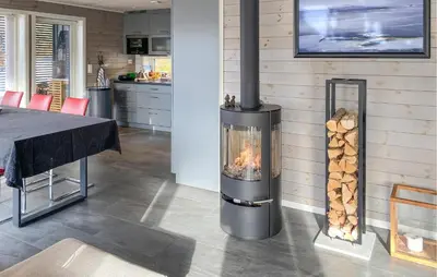 a wood burning stove in a kitchen with a table at 3 Bedroom Awesome Home In Nordfjordeid in Nordfjordeid