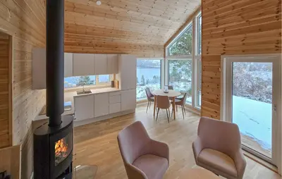 a kitchen and dining room with a fireplace in a house at 2 Bedroom Lovely Home In Bjordal in Hogvær