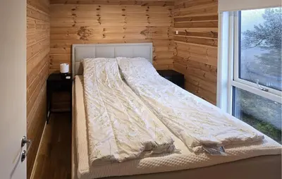 a bed in a small room with a window at 2 Bedroom Lovely Home In Bjordal in Hogvær