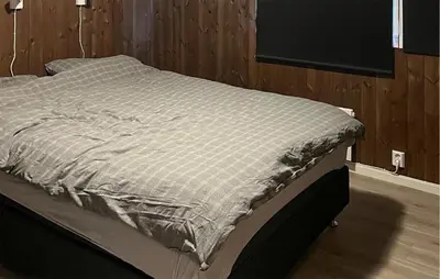 a large bed in a room with wooden walls at Amazing Home In Oppdal in Oppdal