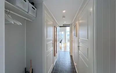 a hallway with white doors and a tile floor at 4 Bedroom Gorgeous Home In Bjugn in Moen