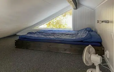 a bed in a room with a window and a fan at 4 Bedroom Gorgeous Home In Bjugn in Moen