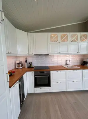 a kitchen with white cabinets and a stove top oven at Hytte v Farstadsanden Anders sandvigsvei 9 in Julshamn