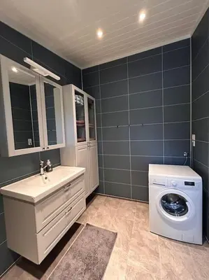 a bathroom with a washing machine and a sink at Hytte v Farstadsanden Anders sandvigsvei 9 in Julshamn