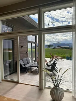a living room with sliding glass doors and a patio at Hytte v Farstadsanden Anders sandvigsvei 9 in Julshamn