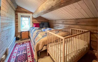 a bedroom with a bed in a wooden room at Awesome Home In Sjusjøen With Sauna in Sjusjøen