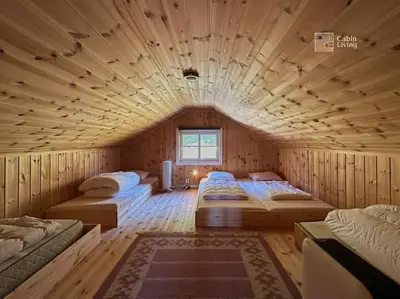 a bedroom with two beds in a wooden room at Luxury cabin Sjusjøen with hot tub, ski in-out, fireplace & WiFi in Ringsaker