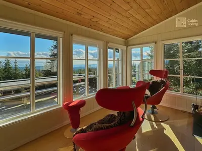 a room with three red chairs and windows at Luxury cabin Sjusjøen with hot tub, ski in-out, fireplace & WiFi in Ringsaker