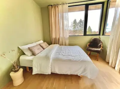 a bedroom with a bed and a chair and a window at Unik funkisbolig leies ut til ski-VM in Lund