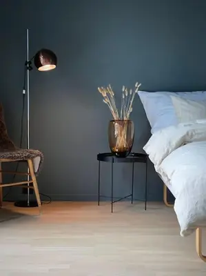 a bedroom with a bed and a table with a vase on it at Unik funkisbolig leies ut til ski-VM in Lund