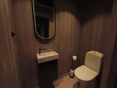 a bathroom with a toilet and a sink and a mirror at OlaHytta - Cozy cabin close to kvitfjell in Tromsnes