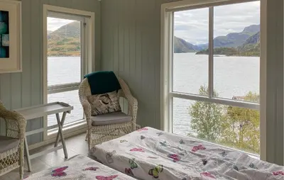 a bedroom with a bed and a view of the water at 4 Bedroom Nice Home In Deknepollen in Måløy