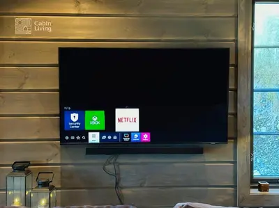 a flat screen tv hanging on a wall at Modern cabin at Høgevarde panoramic view, fireplace and EV station in Granheim