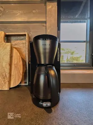 a black blender sitting on the floor next to a window at Modern cabin at Høgevarde panoramic view, fireplace and EV station in Granheim
