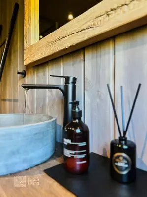a bottle of soap sitting on a counter next to a sink at Modern cabin at Høgevarde panoramic view, fireplace and EV station in Granheim