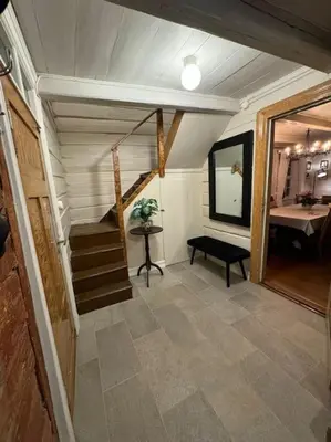 a room with a staircase and a table and a mirror at Nyrestaurert hus fra 1700-tallet in Bjørgo