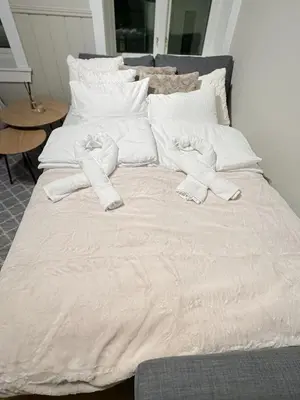 a bed with white sheets and white pillows at Central stay apartment - 301 in Bergen