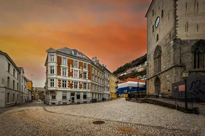 a city street with buildings and a sunset in the background at Central stay apartment - 301 in Bergen