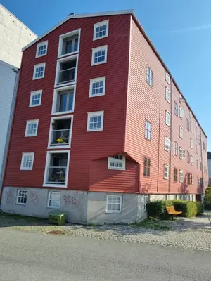 a red building with a bench in front of it at Brygga B&B Trondheim sentrum, privat rom i vårt hjem in Trondheim