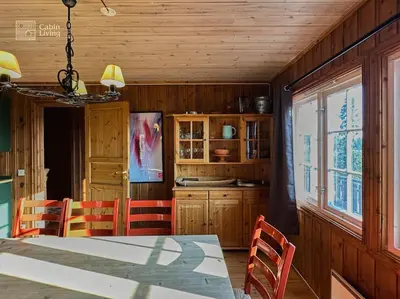 a dining room with a table and chairs and a kitchen at Original Olympic cabin ski in out Hafjell in Hunder