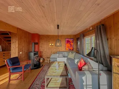 a living room with a couch and a stove at Original Olympic cabin ski in out Hafjell in Hunder