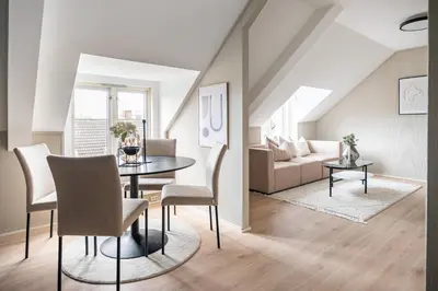 a living room with a table and chairs and a couch at Super Central renovated flat, next to Solsiden, Free Private Parking right outside ! in Trondheim