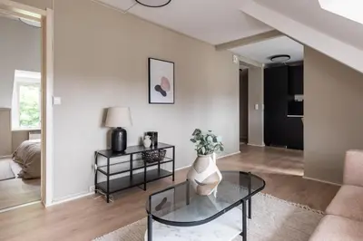 a living room with a vase on a glass table at Super Central renovated flat, next to Solsiden, Free Private Parking right outside ! in Trondheim