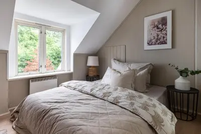 a bedroom with a bed and two windows at Super Central renovated flat, next to Solsiden, Free Private Parking right outside ! in Trondheim