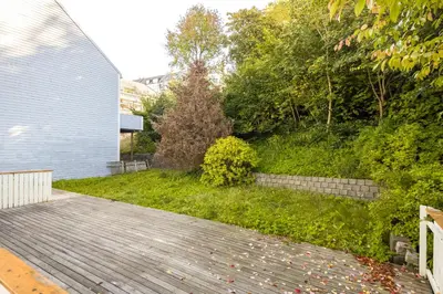 a backyard with a wooden walkway next to a house at Super Central renovated flat, next to Solsiden, Free Private Parking right outside ! in Trondheim